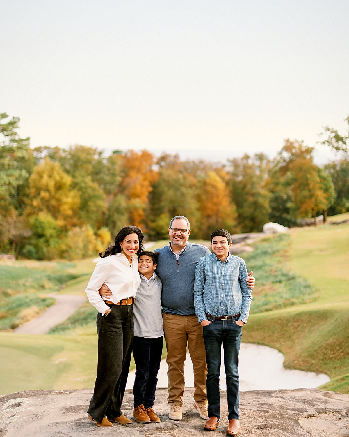 Eisa Shunnara with his wife Tanya and their two sons standing together on a golf course overlook